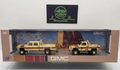 Model GMC trucks in packaging with a desert scene design on a white background