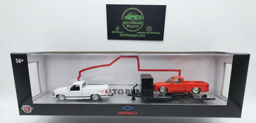 Model truck set with a red truck towing a white truck in a display box.