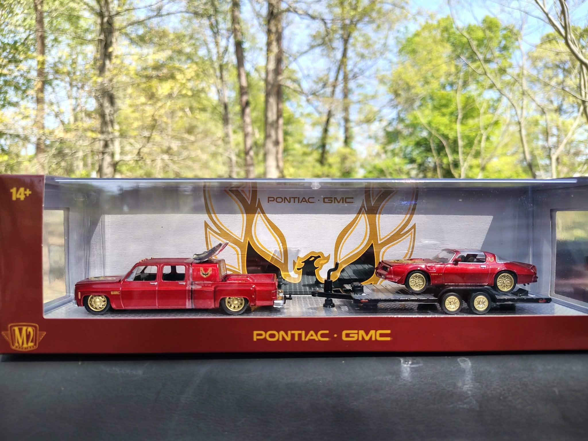 Model truck set in a Pontiac and GMC branded box with trees in the background