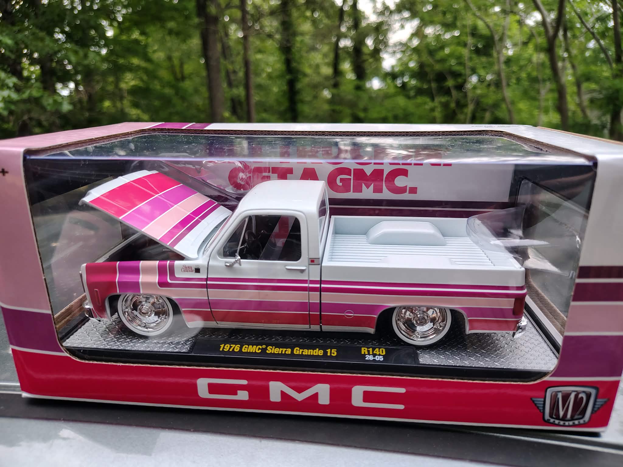 Model GMC truck in a display case with 'Get a GMC' text in the background