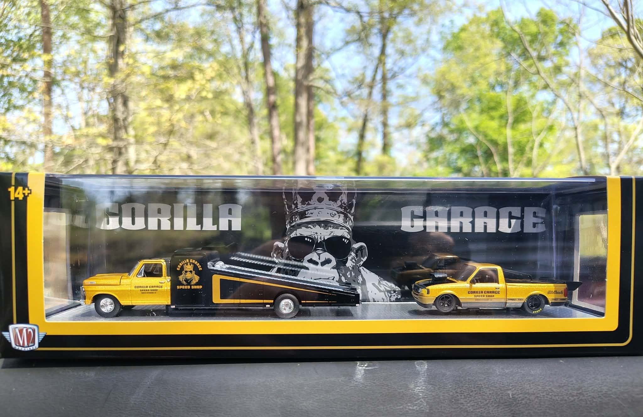 Model truck in a Gorilla Garage display box with trees in the background